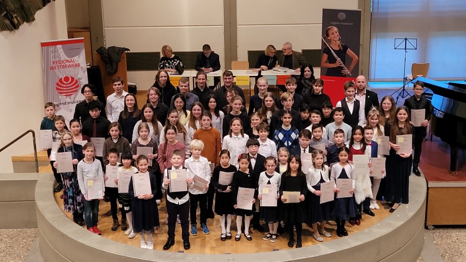 Ein Gruppenbild mit Kindern und Jugendlichen auf einer Bühne.