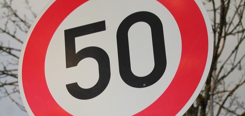 Ein "Tempo 50"-Schild über einem Parkverbot-Schild. 