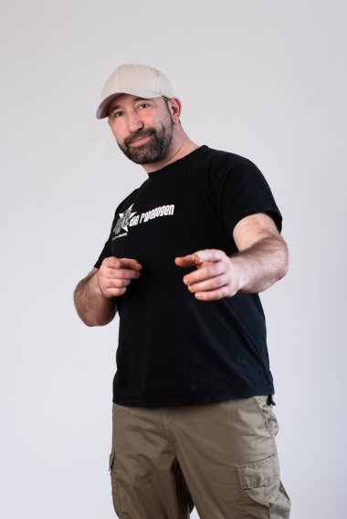 Ein Mann in schwarzem T-Shirt mit Base-Cap.