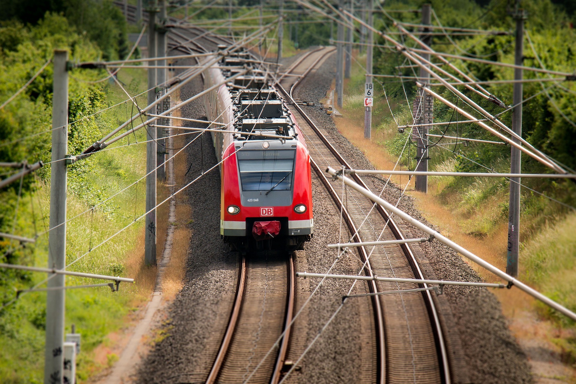 Roter Zug der DB fährt auf Schienen