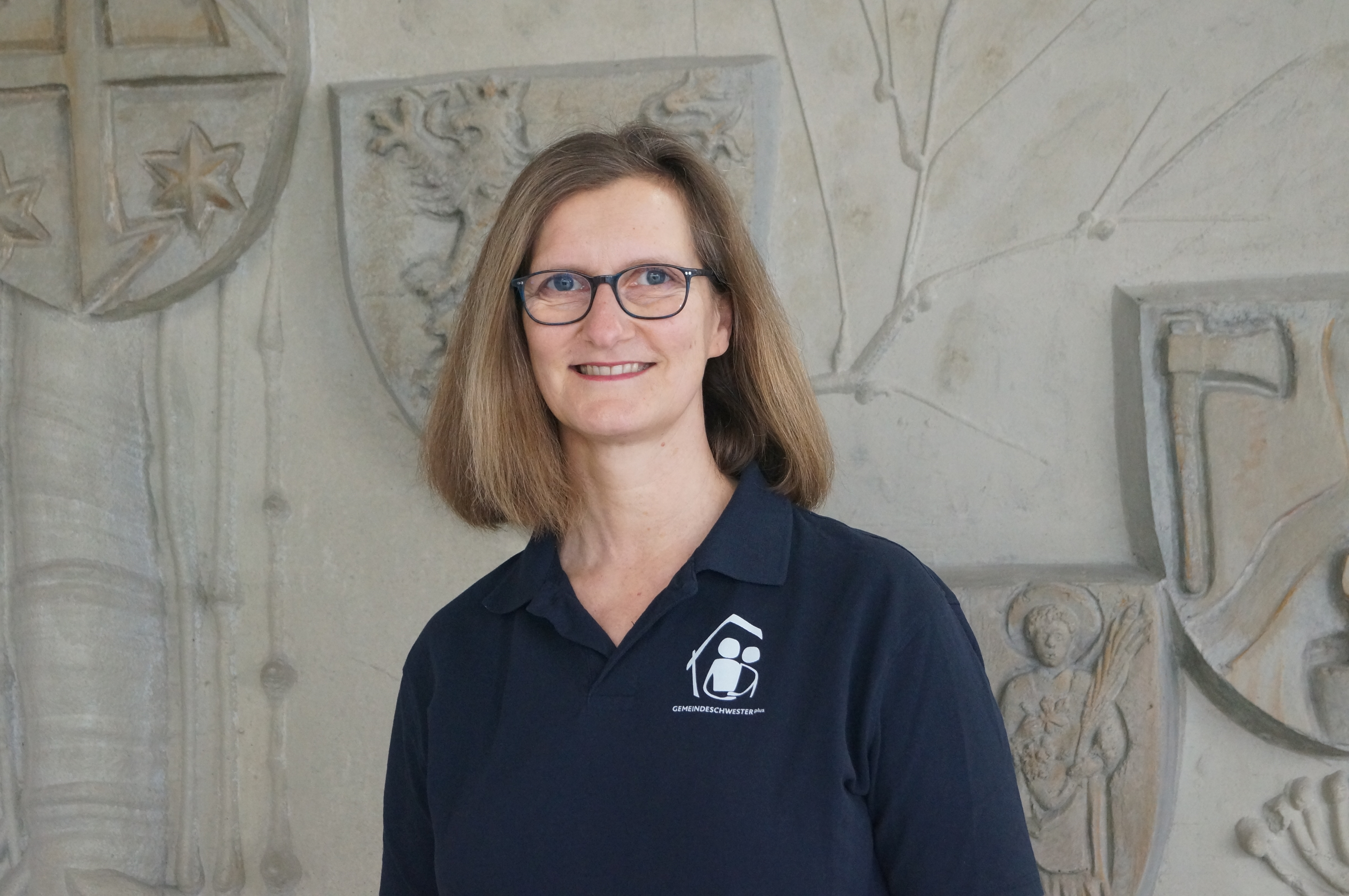 Eine Frau steht vor einer Wand.