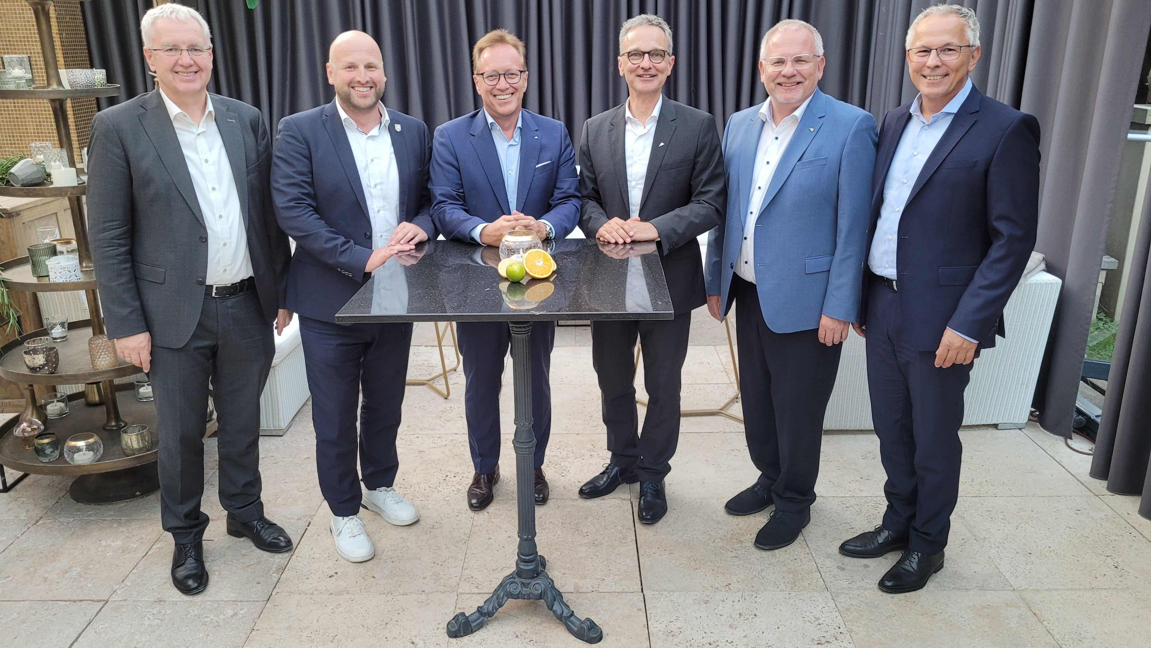 Eine Gruppe Männer steht um einen Tisch.