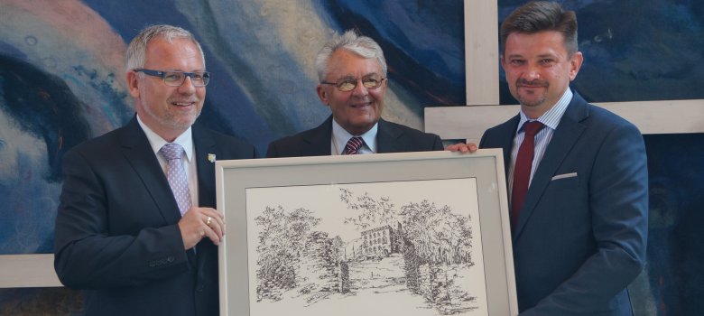 Landrat Hans-Ulrich Ihlenfeld und Altlandrat Georg Kalbfuß übergeben Gemälde vom Hambacher Schloss an den polnischen Landrat Piotr Pospiech