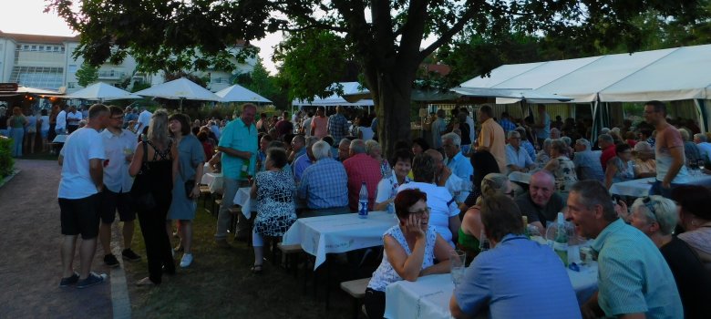 Menschen sitzen an Bierbänken im Park