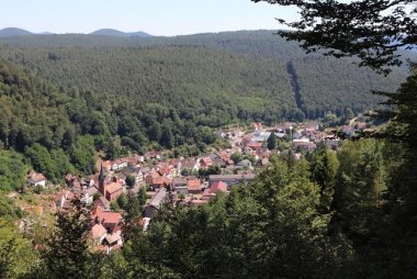 Luftaufnahme von Elmstein, im Tal gelegen, um geben von bewaldeten Hügeln. 