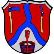 Das Wappen von Frankeneck. von blauem Band gedrittelt. Oben links eine Axt, oben rechts eine Sichel, unten eine rote Bütte mit rotem Rührsieb. 