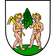 Wappen von Kindenheim. Auf Weiß zwei naturfarbene Kinder, die auf grünem Boden stehen. Eines trägt eine Hacke, das andere ein Rebmesser. In der Mitte halten beide gemeinsam einen grünen Trauben.
