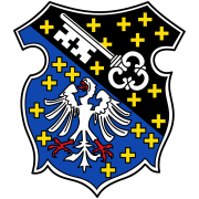 Wappen von Neuleiningen. Diagonal von links oben nach rechts unten geteilt, übersät von gelben Sternen. Links auf Blau ein weißer Adler, rechts auf Schwarz ein weißer Schlüssel. 
