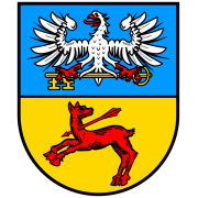 Wappen von Obrigheim. Obere Hälfte ein weißer Adler mit gelbem Schlüssel auf Hellblau. Darunter auf Gelb eine rote, am Hals von einem Pfeil durchbohrte Hirschkuh. 