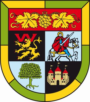 Wappen der Verbandsgemeinde Wachenheim. Gelb-hellgrüne Umrahmung. Wappen in der Höhe zirka gedrittelt. oben quer eine Rebe mit Blättern und einem Trauben. Darunter: Auf schwarzem Grund oben links ein Löwe, unten rechts eine Burg. Auf weißem Grund oben rechts ein Ritter mit Schwert auf einem Pferd. Unten links ein grüner Baum. 